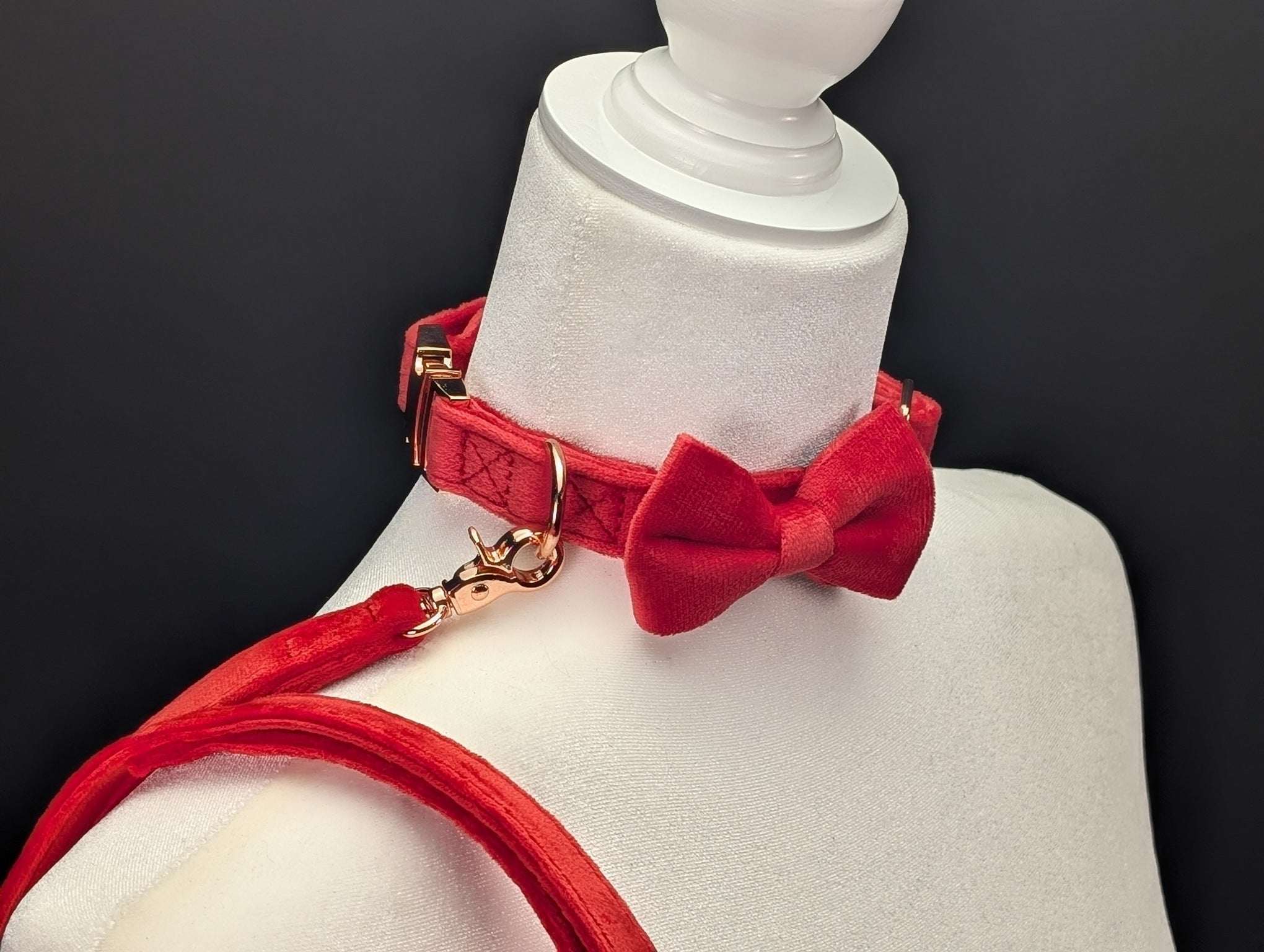 Red velvet collar with a bow tie on a mannequin against a black background