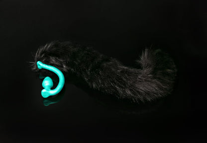 Long hair, black cat tail butt plug made of silicone and faux fur, but the plug is hooked so when worn, the tail sits at the bottom of the lumbar area. It’s laying flat on a black background.::Mint