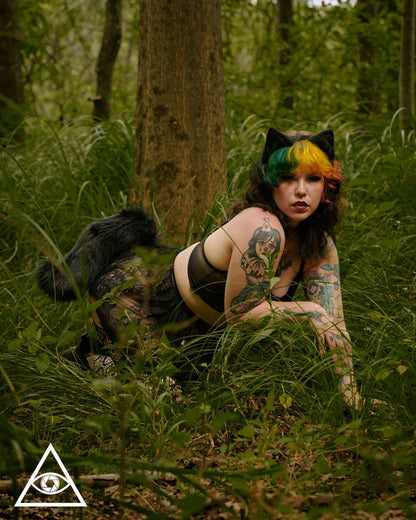 Person wearing midnight wolf tail in forest